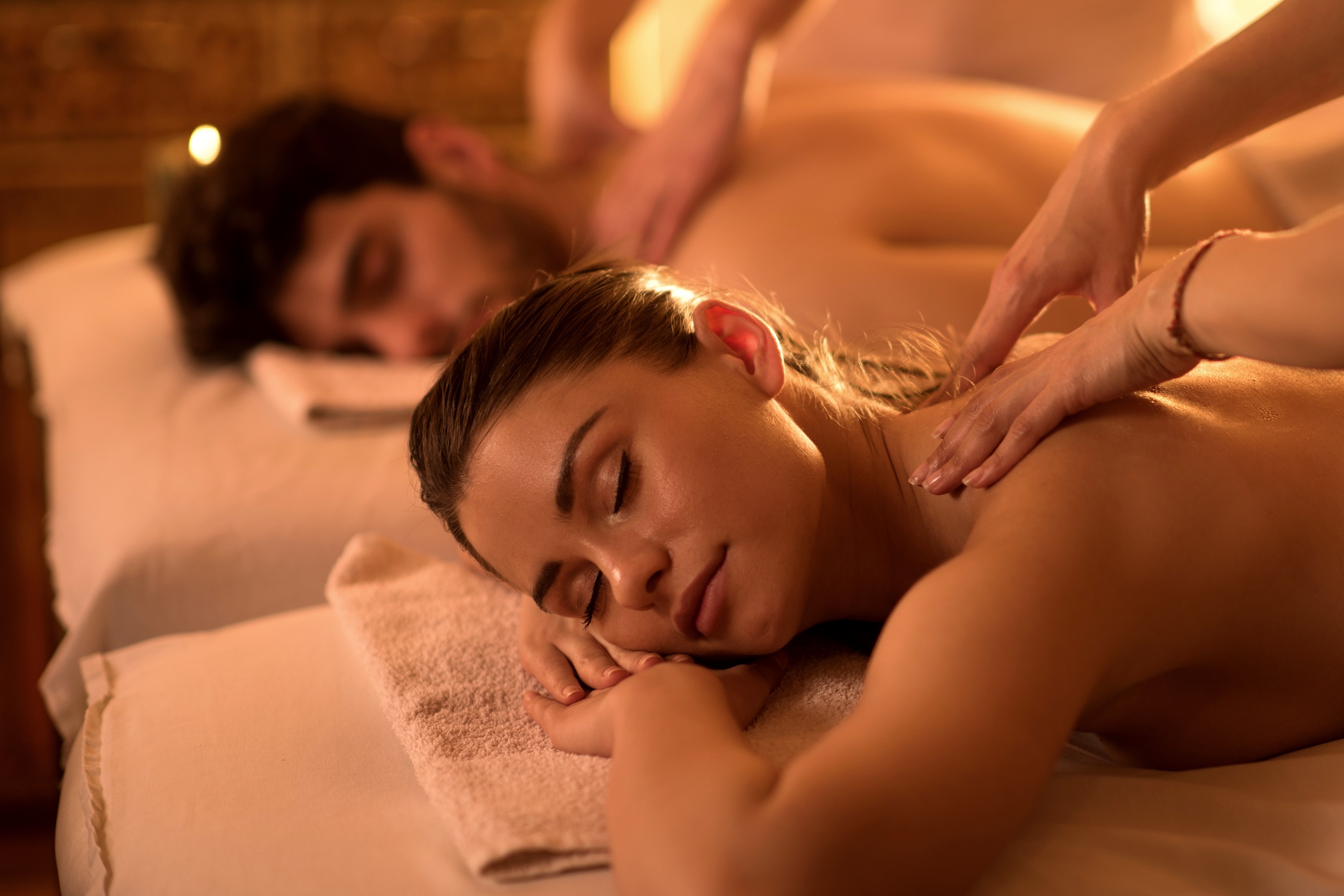 Young couple enjoying at spa during back massage.